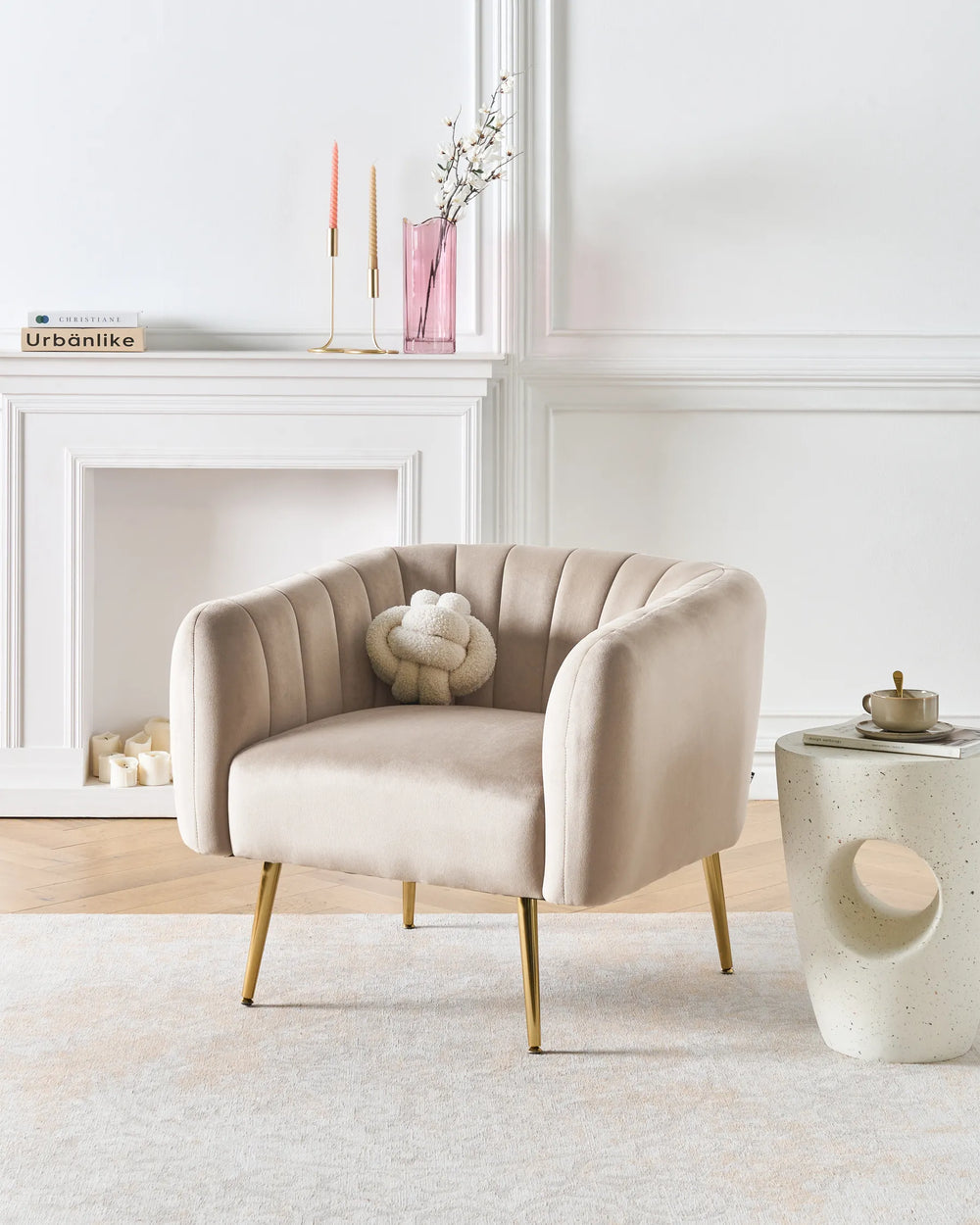 Beige armchair in a stylish living room with a fireplace and decorative items.