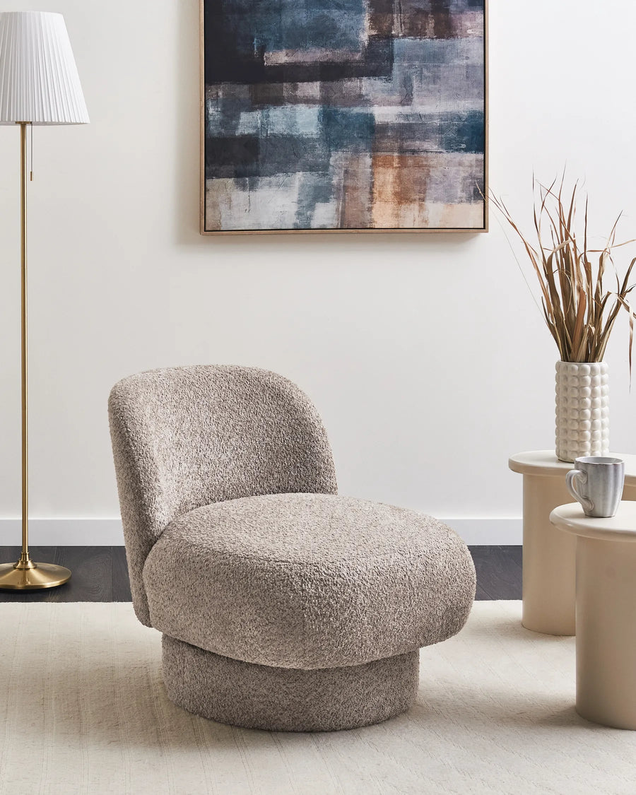 Beige armchair in a modern living room with abstract art and decor.