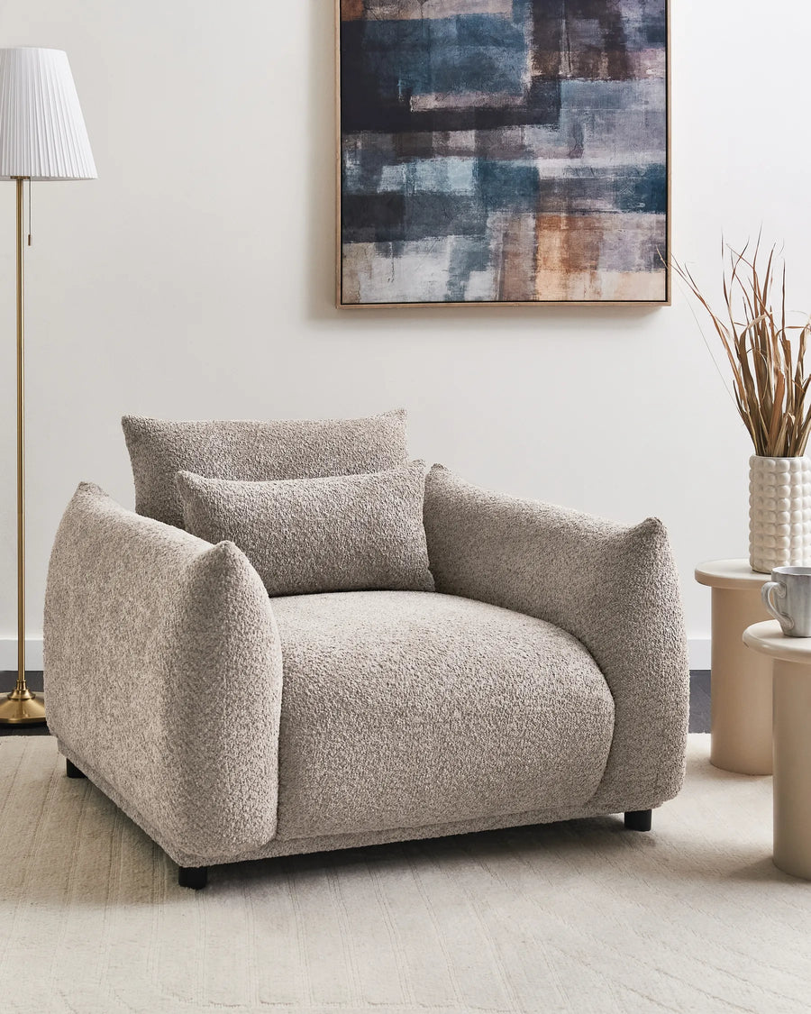 Beige armchair in a living room with abstract art on the wall