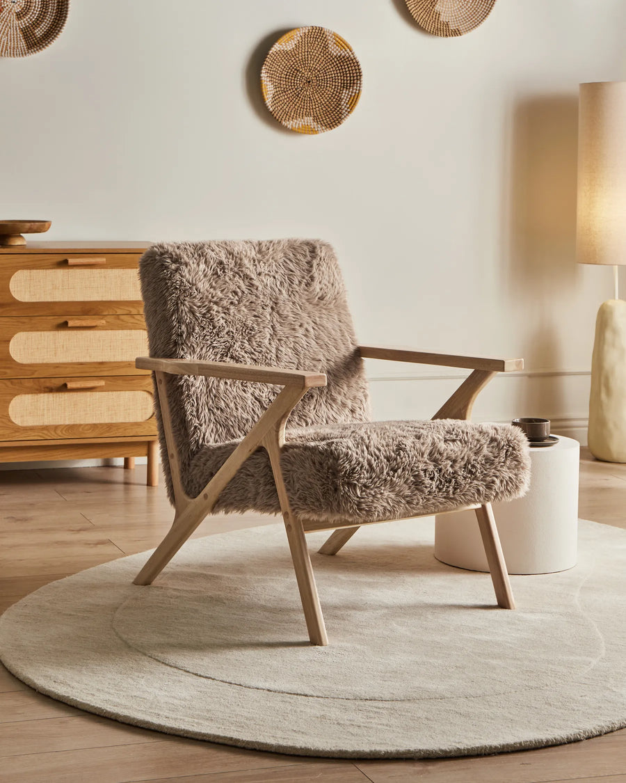 Cozy armchair with fluffy cushion in a warm-toned room.