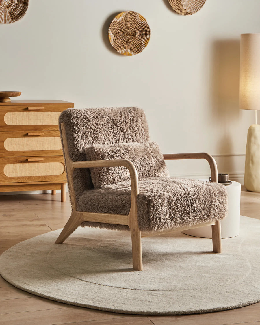 Fluffy armchair in a room with wooden furniture and decorative elements.
