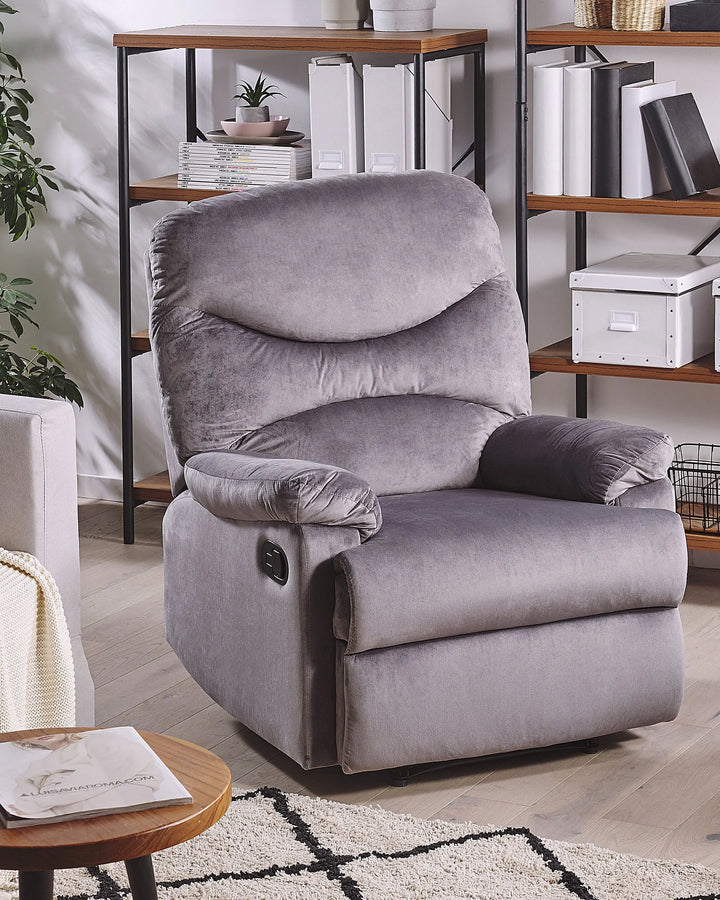 Gray recliner chair in a living room setting with shelves and a table.