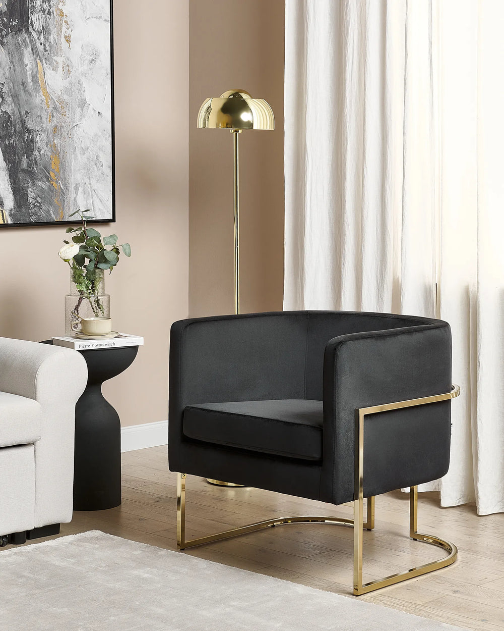 Modern black armchair with gold accents in a stylish living room setting.