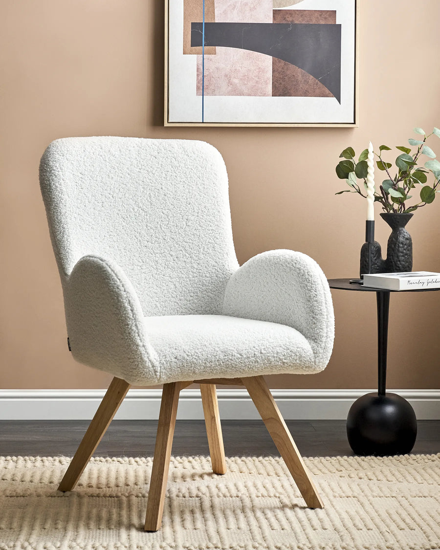 White armchair in a room with a abstract painting on the wall