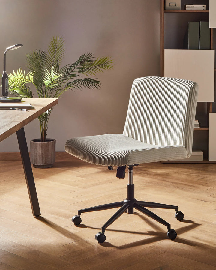 Gray office chair in a home office setting with a desk, plant, and bookshelf.