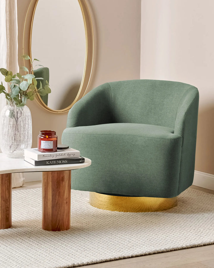 Green armchair with gold base in a room setting with a mirror and small table.