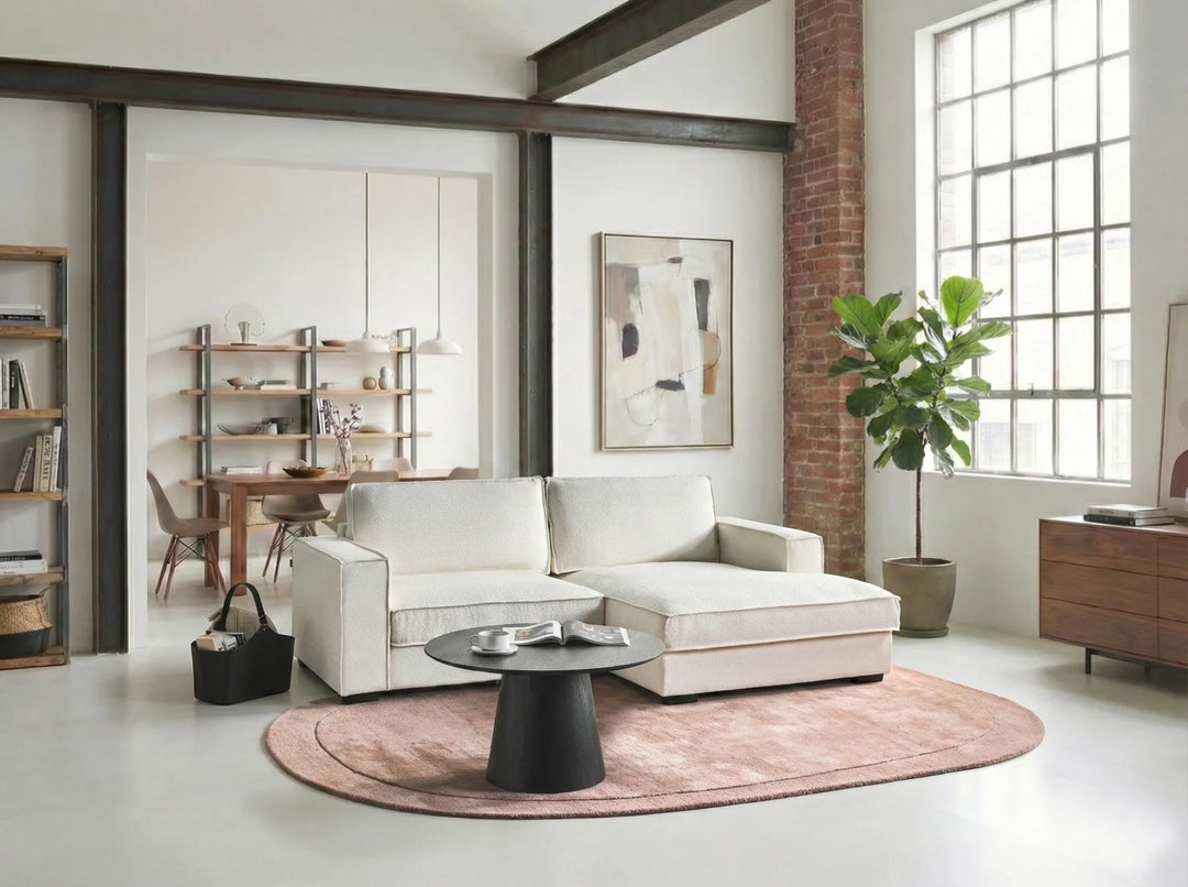 Modern living room with a white sofa, coffee table, and decorative elements.