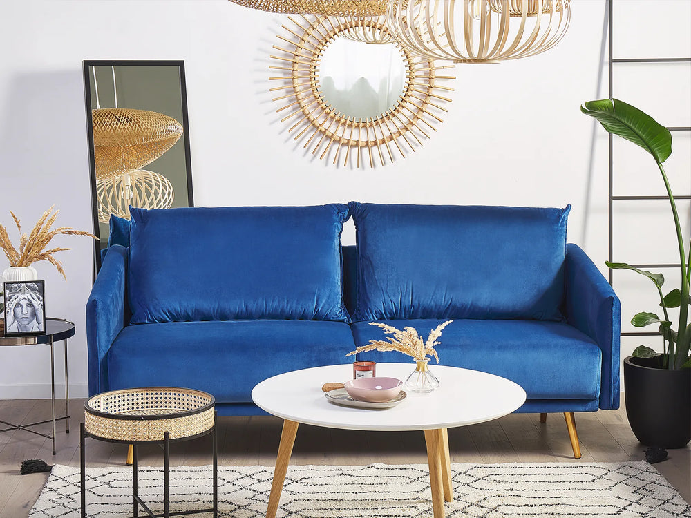 Blue sofa in a living room with decorative elements and a white wall.