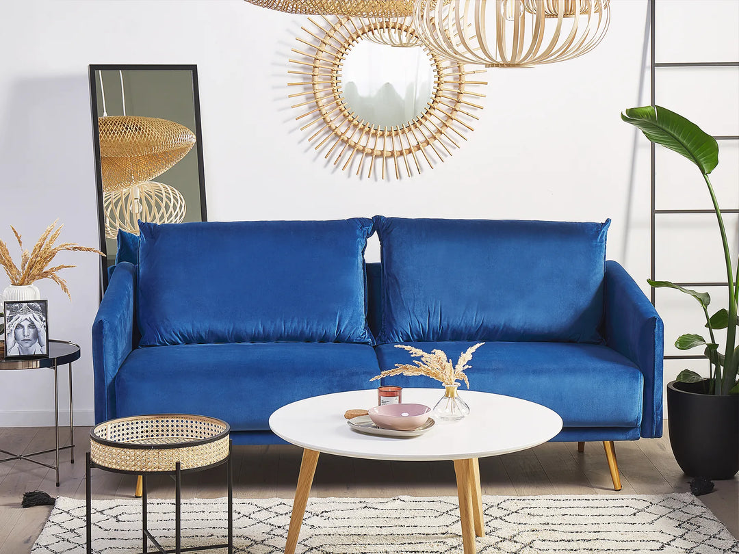Blue sofa in a living room with decorative elements and a white wall.