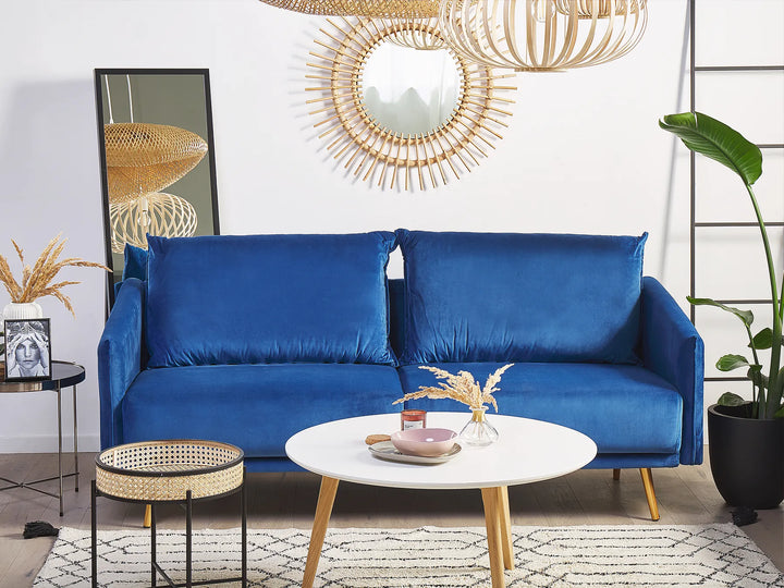 Blue sofa in a living room with decorative elements and a white wall.