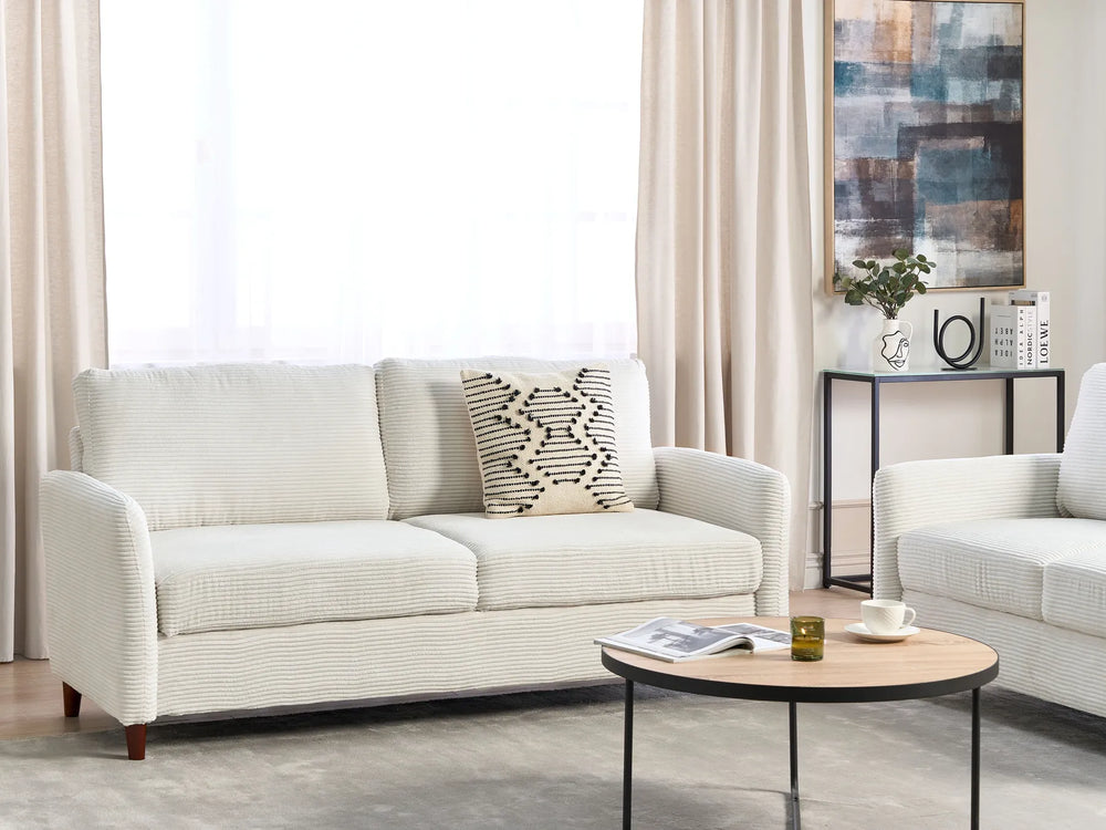 Modern living room with a white sofa, coffee table, and decorative items.