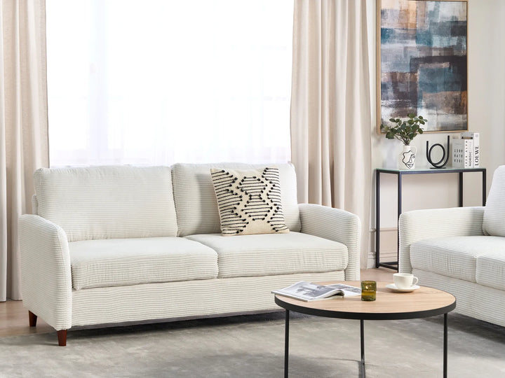 Modern living room with a white sofa, coffee table, and decorative items.