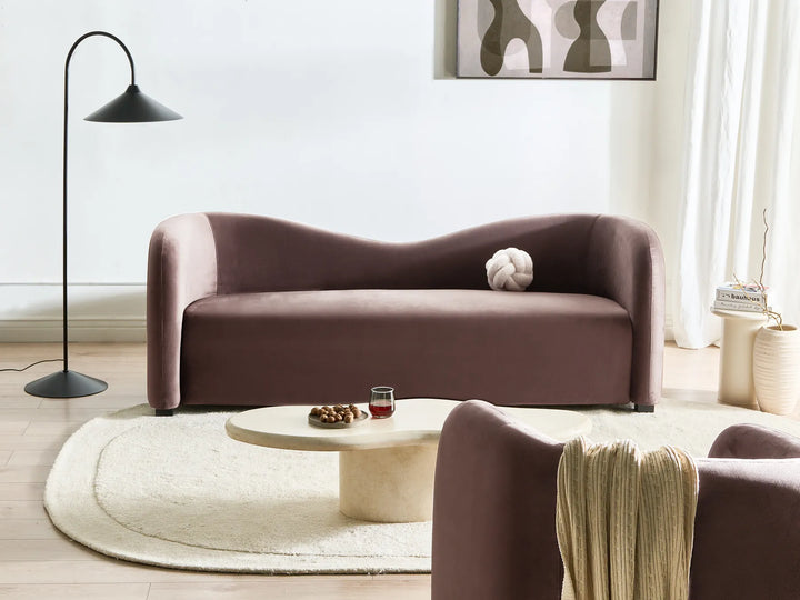 Modern living room with a brown sofa, round coffee table, and abstract art on the wall.