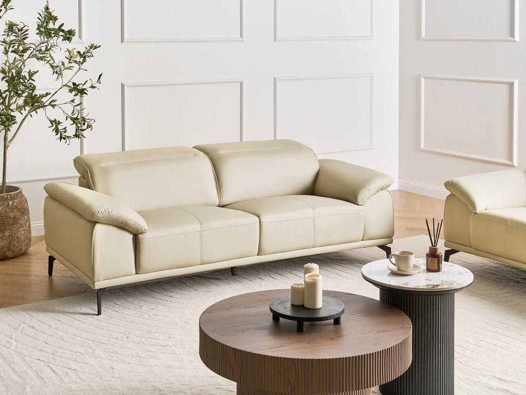 Beige sofa in a modern living room with wooden coffee table and decorative items.