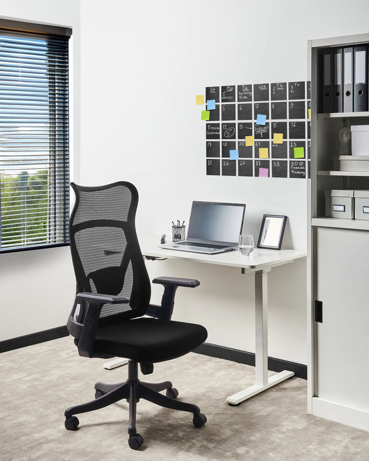 Modern office setup with a black ergonomic chair, white desk, and office supplies.