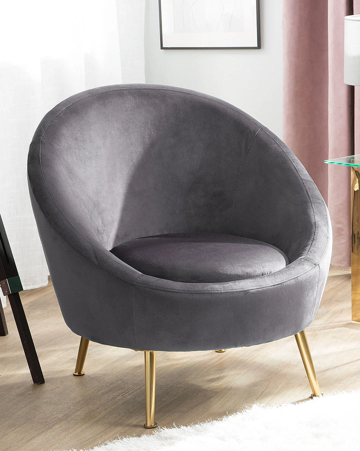 Gray velvet armchair with gold legs in a room setting