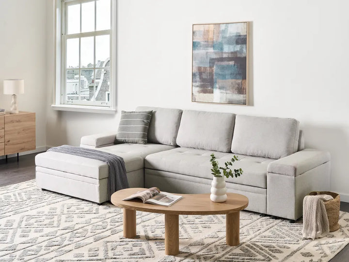 Modern living room with a sectional sofa, coffee table, and decorative elements.
