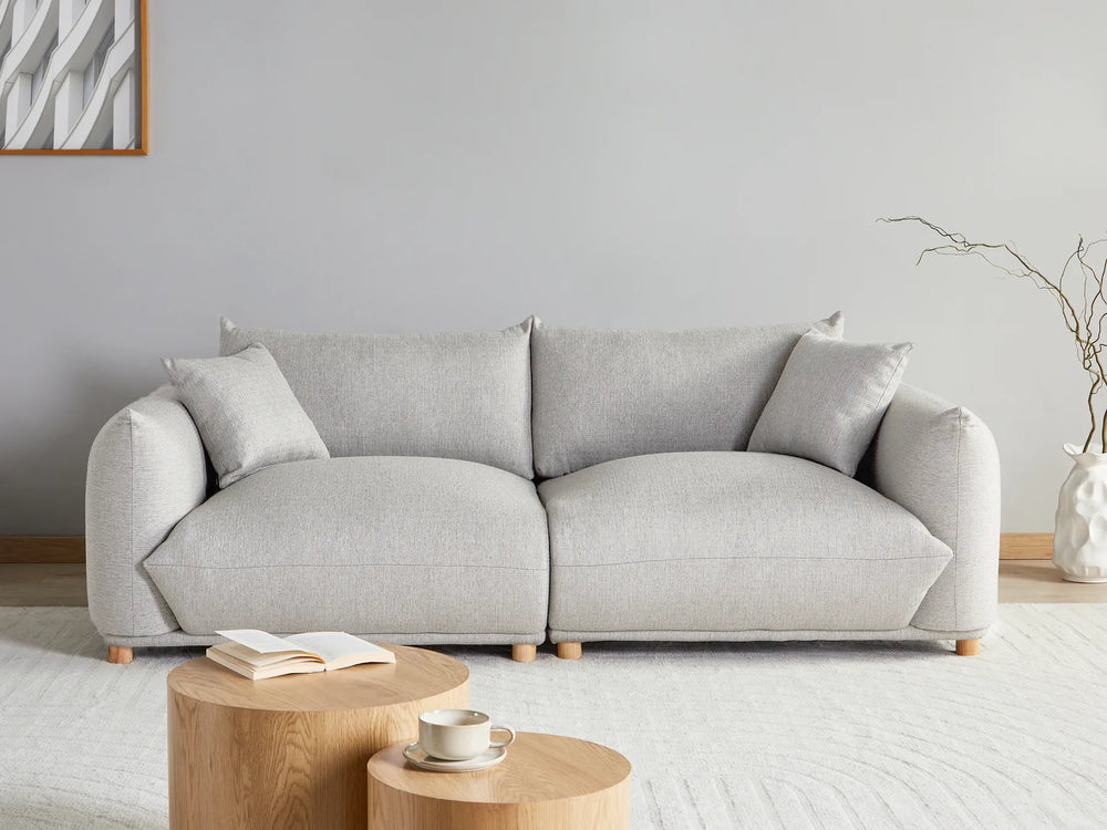 Gray sofa in a living room with a small wooden table and decorative items.