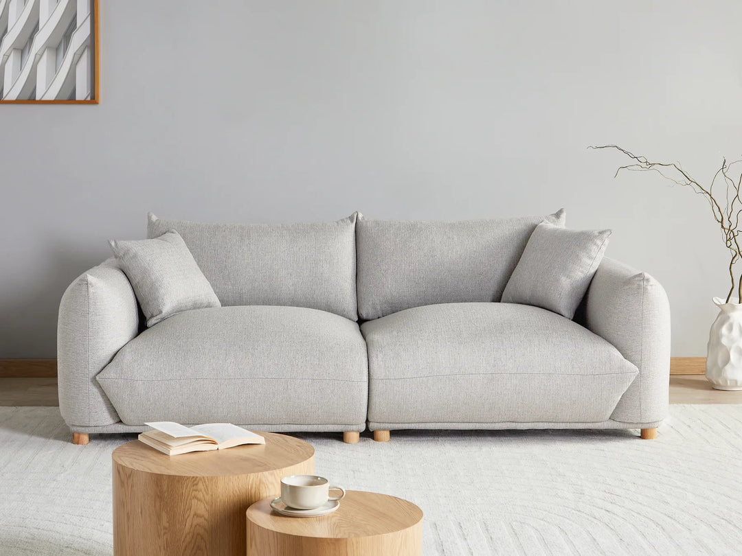 Gray sofa in a living room with a small wooden table and decorative items.