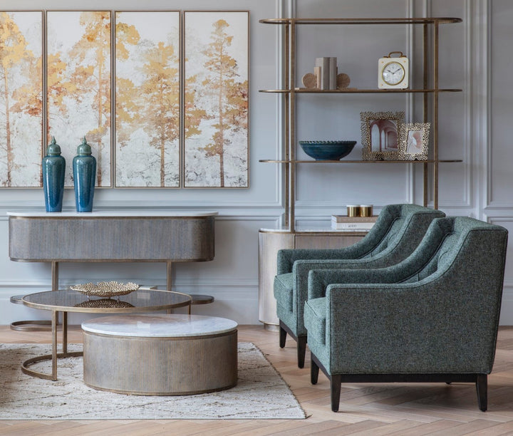 Modern living room with gray armchairs, round coffee table, and decorative wall art.