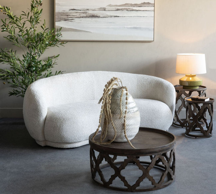 Modern living room with a white sofa, decorative table, and abstract painting on the wall.