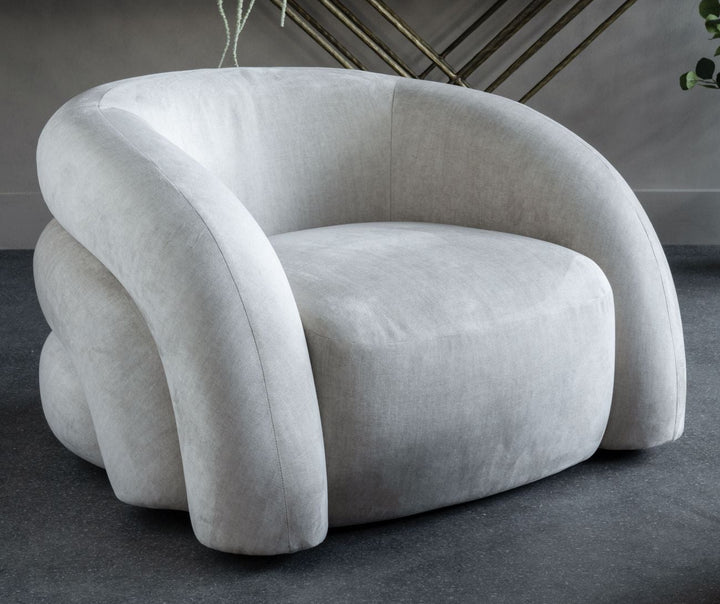 Modern gray armchair in a room with a decorative table and plants.