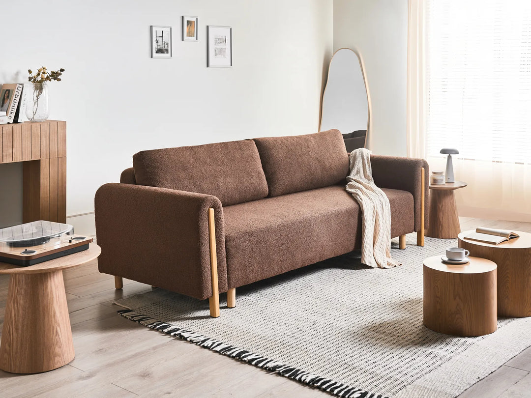 Brown sofa in a living room with wooden tables and decor