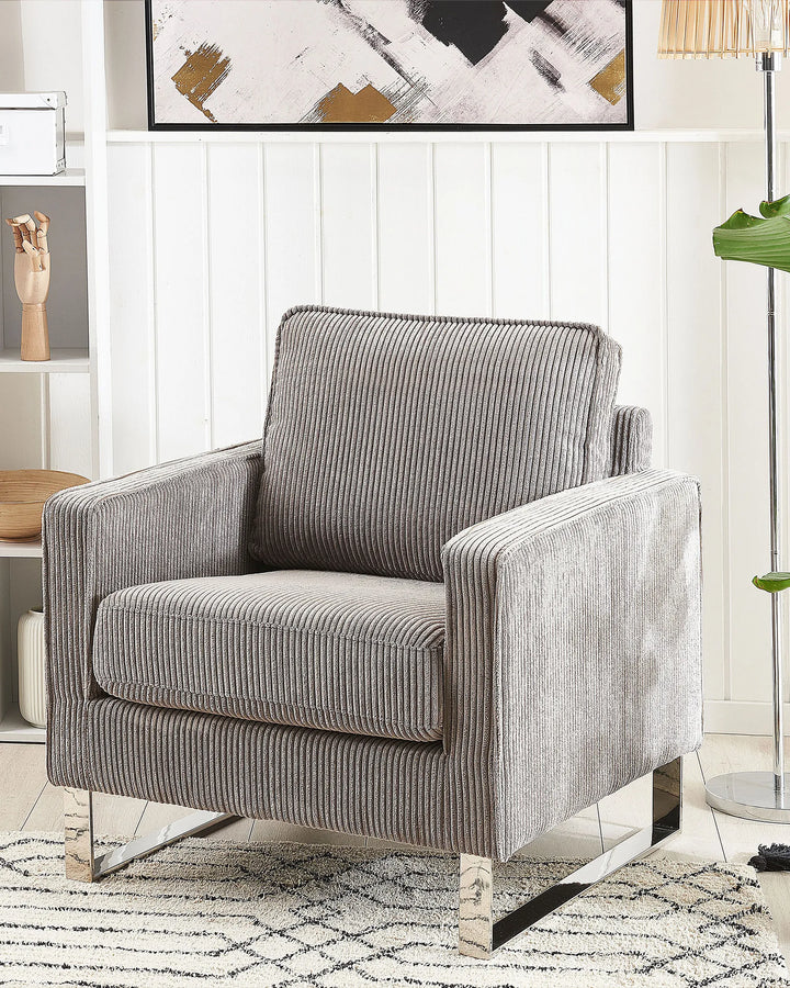 Gray striped armchair in a living room setting with abstract art on the wall.