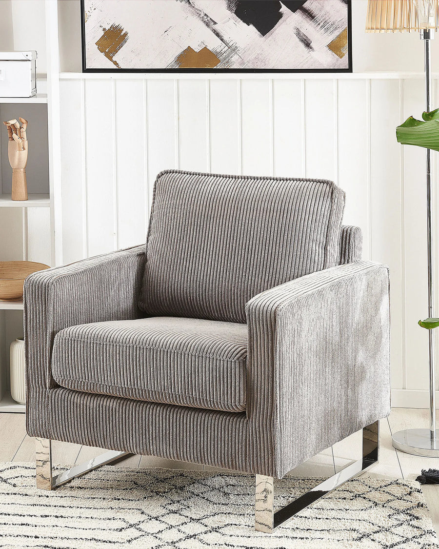 Gray striped armchair in a living room setting with abstract art on the wall.
