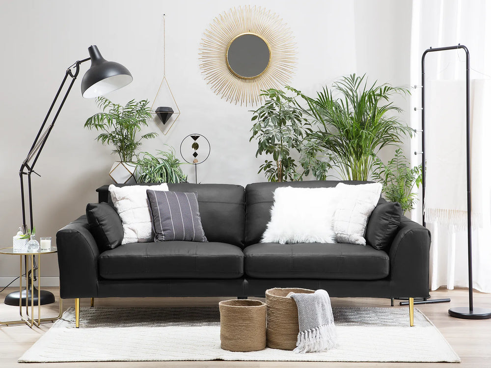 Modern living room with a gray sofa, decorative pillows, and plants.