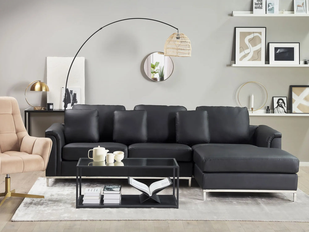 Modern living room with a black sectional sofa, coffee table, and decorative items.