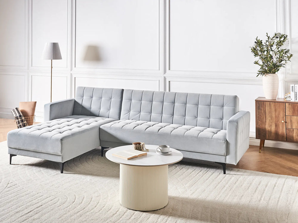 Gray sectional sofa in a modern living room with a coffee table and decorative items.