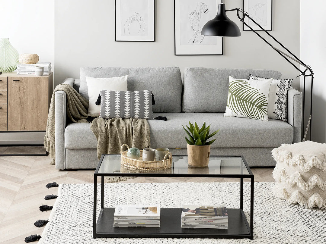 Modern living room with a gray sofa, coffee table, and decorative items.