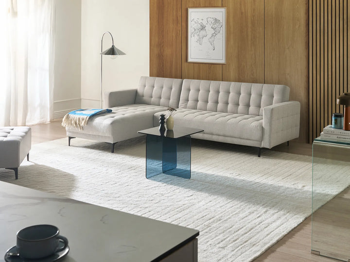 Modern living room with a gray sectional sofa, coffee table, and decorative elements.