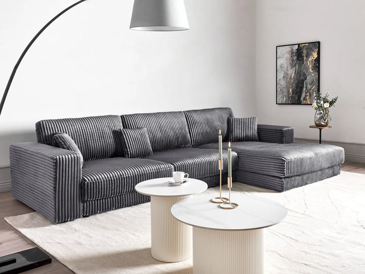Modern living room with a gray sectional sofa, coffee table, and decorative elements.