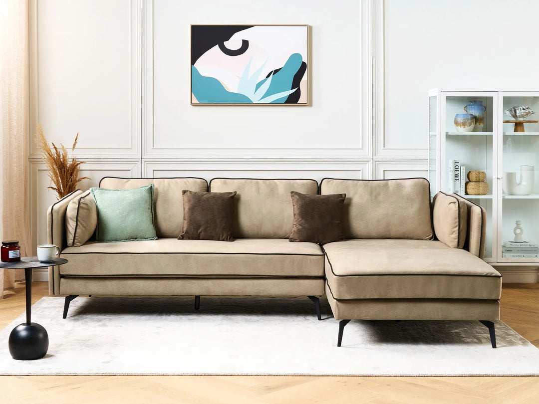 Beige sectional sofa in a living room with decorative pillows and a abstract painting on the wall.