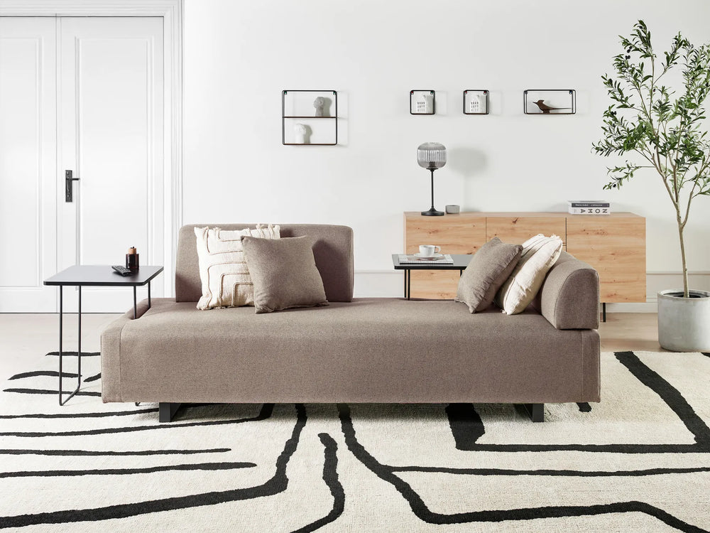 Modern living room with a brown sofa, coffee table, and decorative elements.