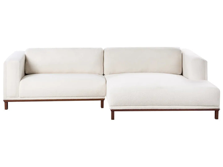 Off-white bouclé left-hand corner sofa with wooden legs and plush cushions, modern L-shaped design