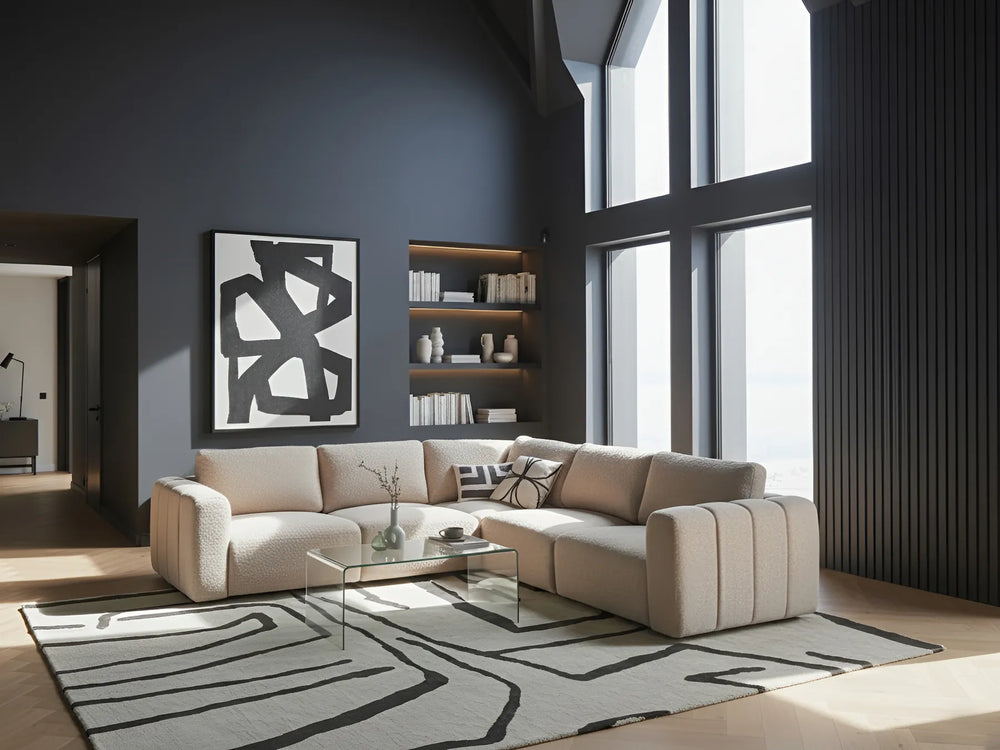 Modern living room with a beige sectional sofa, coffee table, and abstract art on a gray wall.