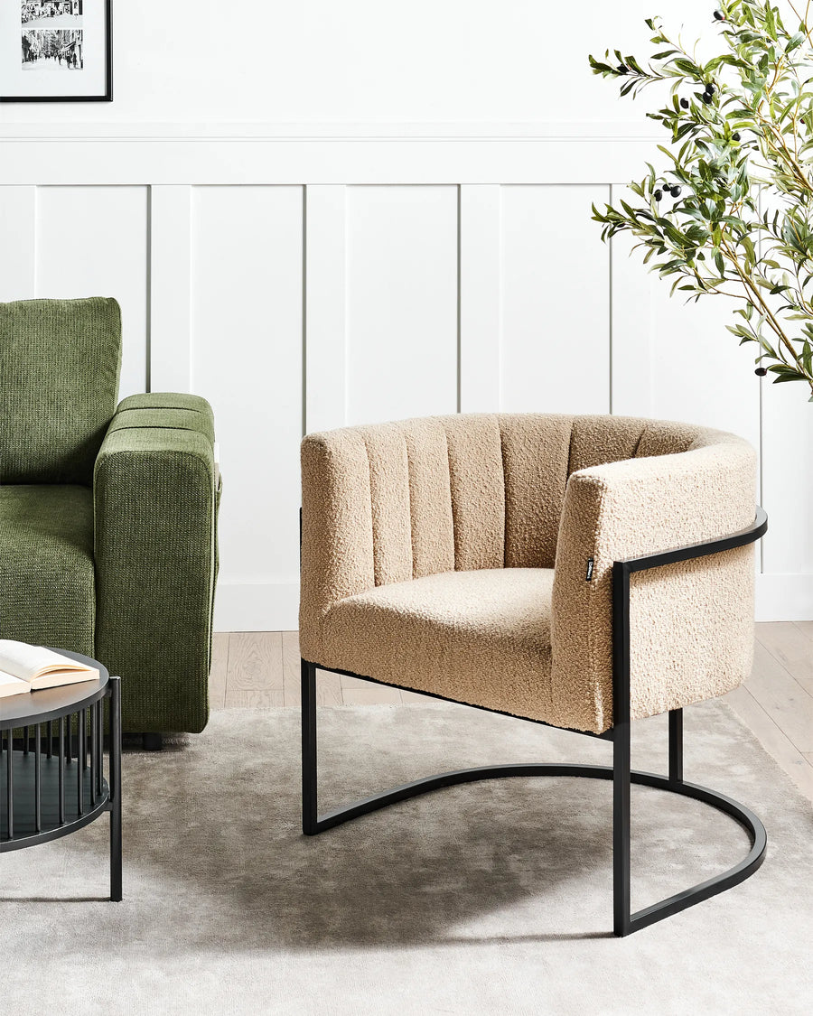 Beige armchair with black metal frame in a modern living room setting