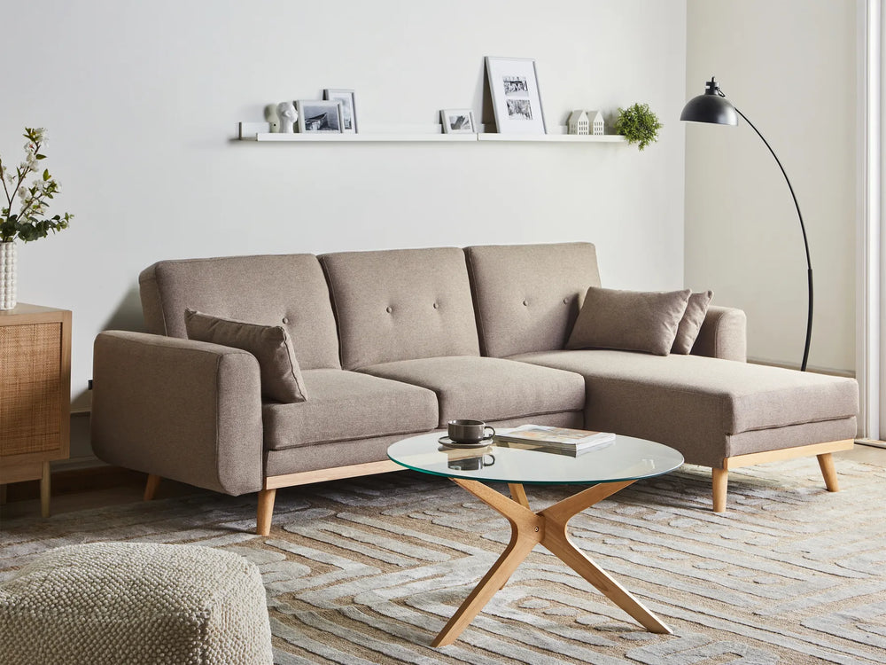 Modern living room with a beige sectional sofa, coffee table, and decorative items.