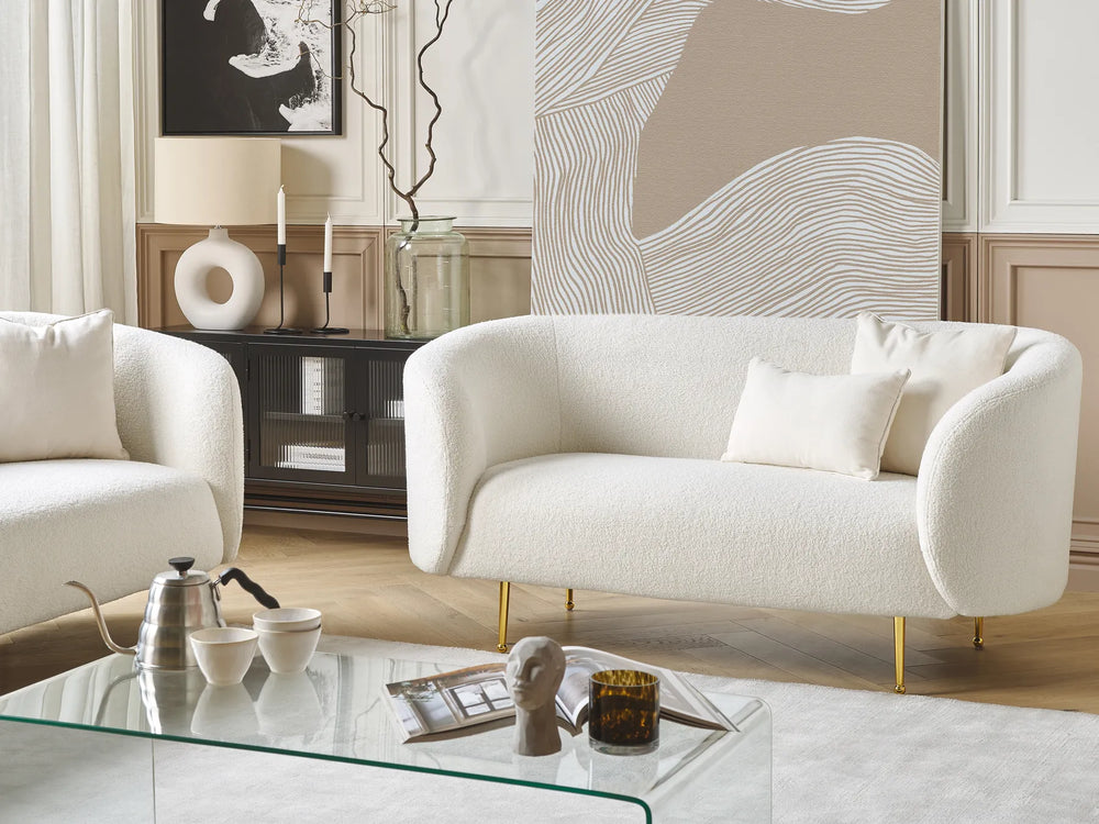 Modern living room with a white sofa, armchair, and glass coffee table.