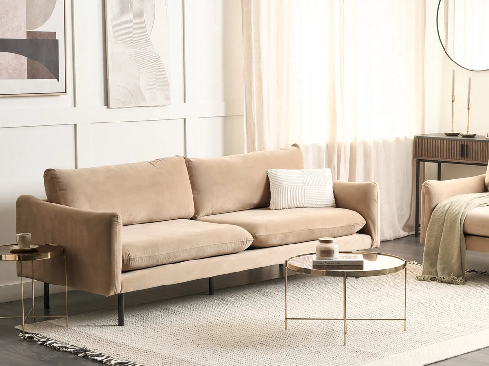 Beige sofa in a modern living room with gold coffee tables and neutral decor.