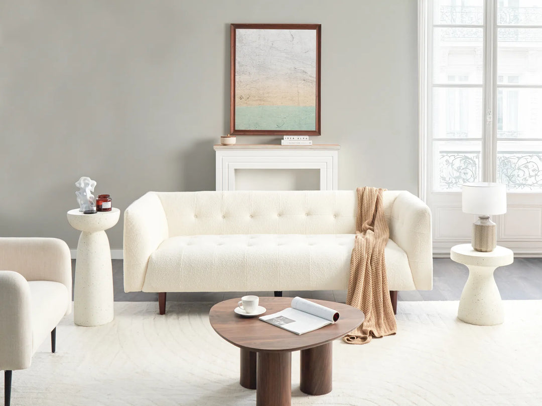 Modern living room with a white sofa, wooden coffee table, and decorative items.