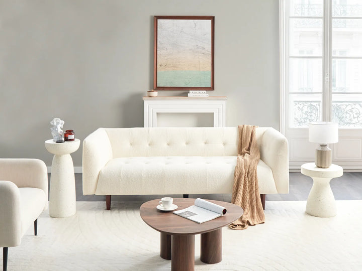 Modern living room with a white sofa, wooden coffee table, and decorative items.
