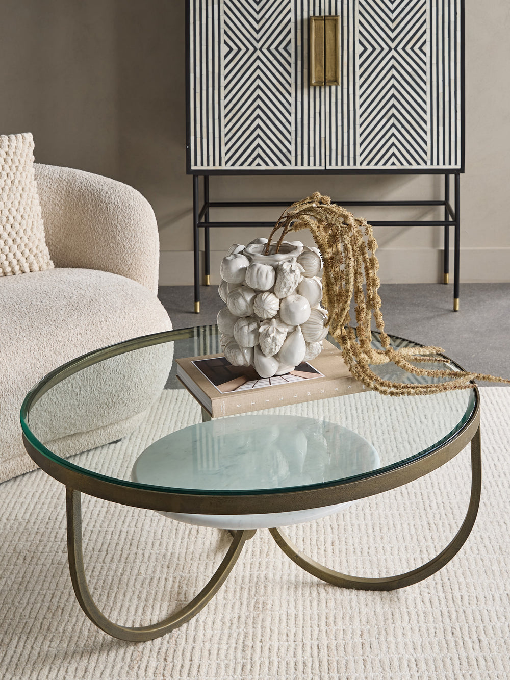 Glass coffee table with decorative items in a living room setting