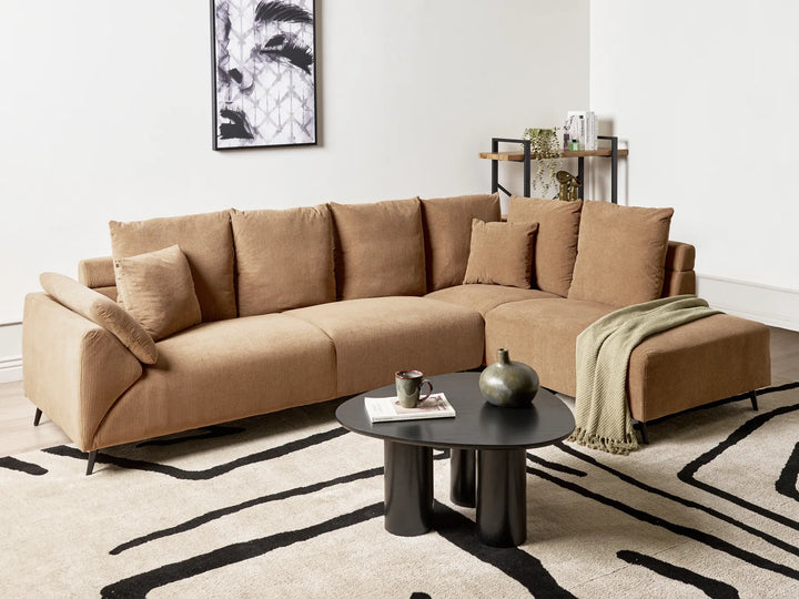 Brown sectional sofa in a living room with a coffee table and decorative items.