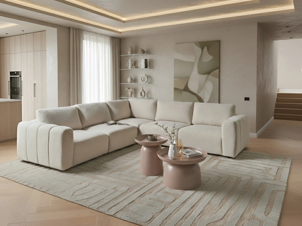 Modern living room with a beige sectional sofa, coffee tables, and abstract art on the wall.