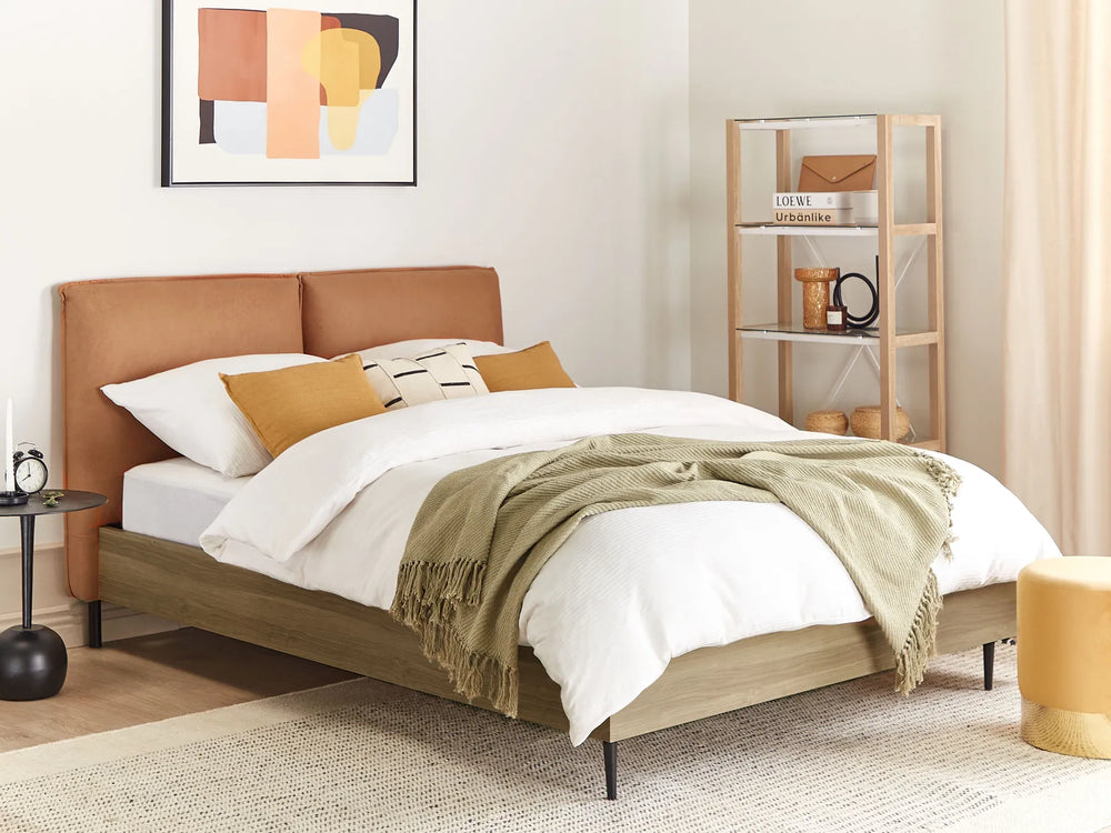 Bedroom with a bed featuring a brown headboard, white bedding, and a green throw blanket.