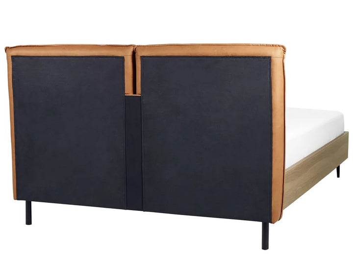 Bed with black upholstered headboard and brown leather trim on a white background
